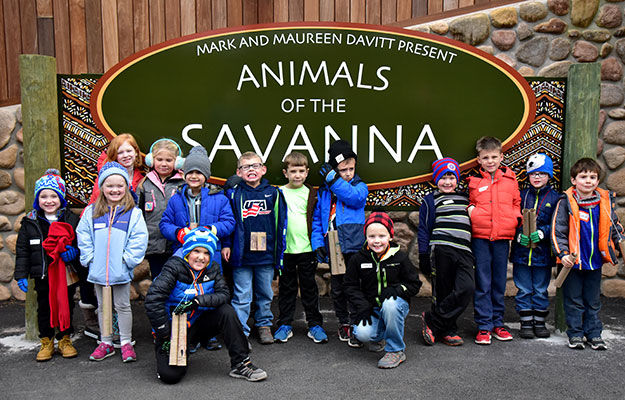 ZooCampers smiling in front of Animals of the Savanna sign